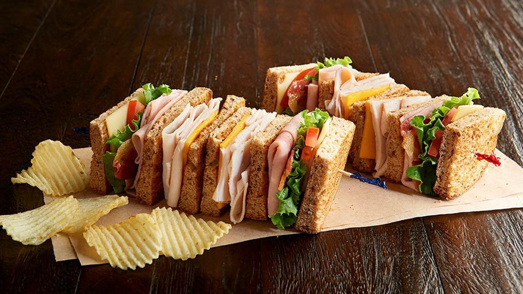 Deli Club Sandwich Regular · Nitrite-free ham, roasted turkey breast, bacon, cheddar, Swiss, leafy lettuce, tomato, mayo, toasted multigrain wheat. Served with chips or baked chips (150/100 cal) and a pickle (5 cal).