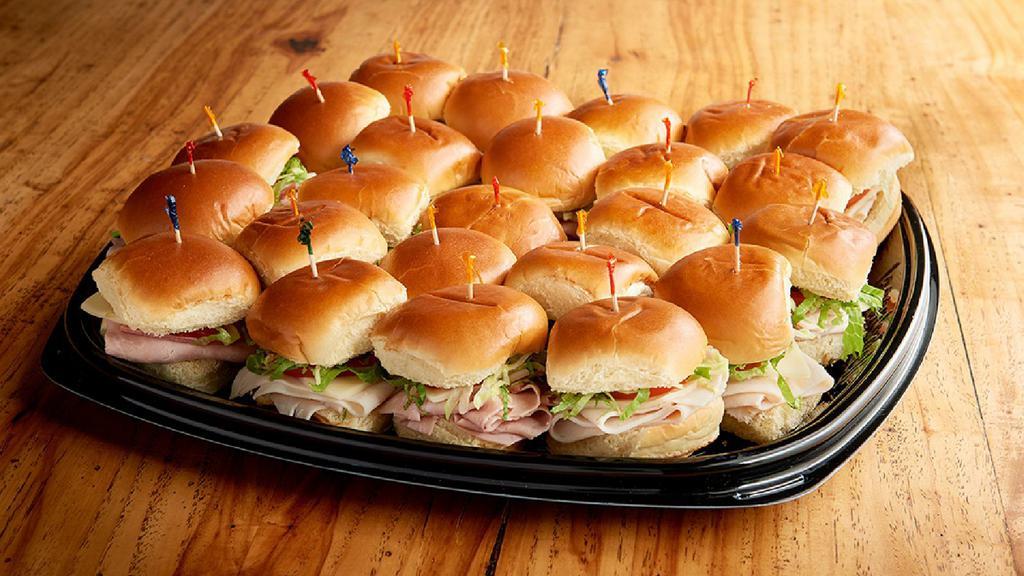Deli Sliders Tray (3750 Cal) · Cold, mini sandwiches on potato slider buns; 12 Roasted Turkey Sliders & 12 Ham-Salami Sliders with provolone, shredded lettuce and Roma tomato. Mayo and mustard on the side. (Serves 12)