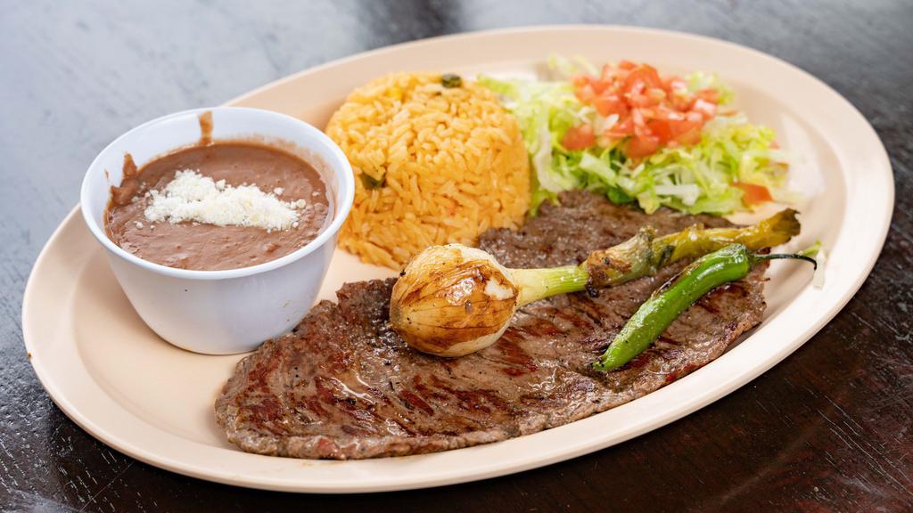 Carne Asada (Grilled Steak) · Grilled steak with scallion on top with 5 tortillas,only  2 companions, rice, beans, salad,fries, maduros, sweet plantains, or tostones.