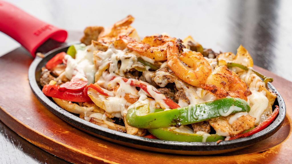 Fajitas Mixta (Steak, Chicken & Shrimp Fajitas) · Marinated grilled strips of beef, chicken, and shrimp seared with cheese, onions, bell peppers, topped with mozzarella cheese  with 5 tortillas,only  2 companions, rice, beans, salad,fries, maduros, sweet plantains, or tostones.