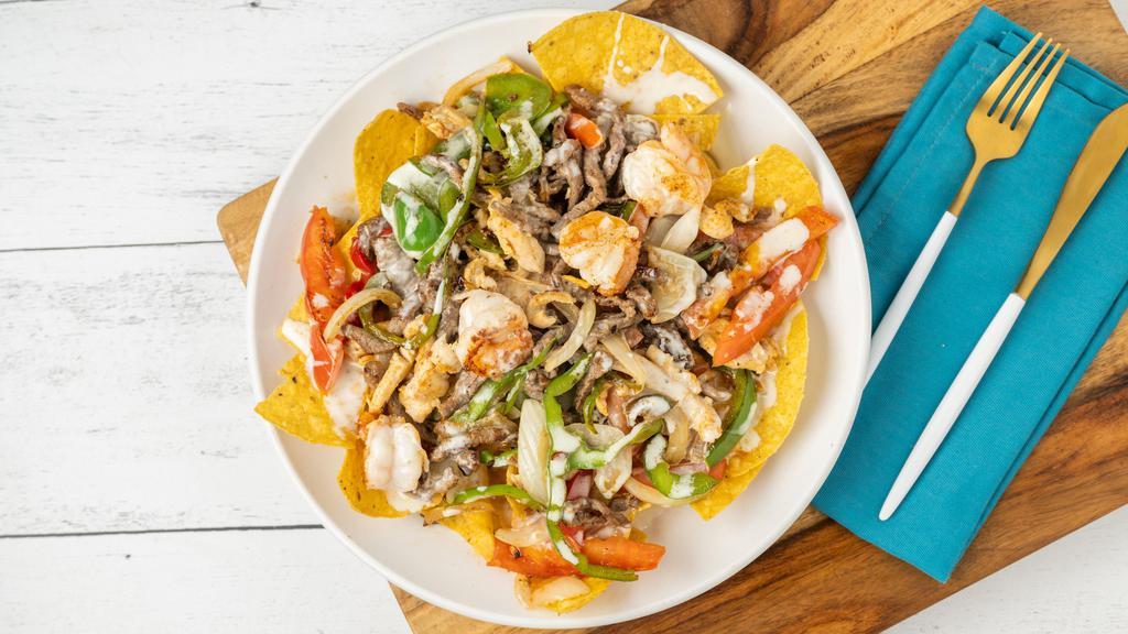 Fajitas Nachos · Chicken, steak and shrimp grilled with onions, bell peppers and tomatoes. Topped with cheese dip.