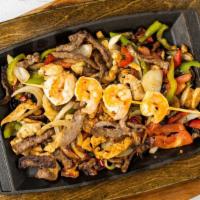 Fajitas Texanas · Chicken breast, shrimp, and grilled steak with onions, bell peppers and tomatoes. Served wit...