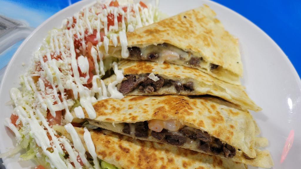 Surf & Turf Quesadilla · A flour tortilla stuffed with cheese, steak and shrimp served with a side sriracha ranch and sour cream.