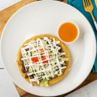 Sope · A masa corn patty topped with refried beans, lettuce, pico de gallo, sour cream and queso fr...