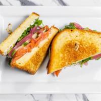 Salmon Lox Sandwich    · Smoked Salmon, chive cream cheese, sliced tomato, dressed arugula, and pickled red onion, wi...