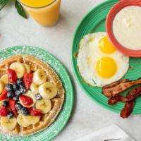Florida Sunshine Waffle Breakfast · A golden Belgian waffle topped with bananas, strawberries, blueberries and powdered sugar.  ...