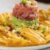 Tuna Tartar · Yellowfin tuna served in a tower formation. Layered with diced tomatoes and avocado. Topped ...