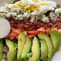 Cobb Salad · Bed of mixed greens topped with egg, bacon, avocado, tomato, crumbled blue cheese, and a sid...