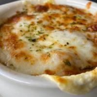 French Onion Soup · Served in a bowl and topped with croutons, mozzarella, and gruyere cheese.