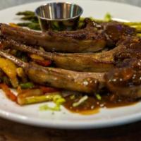 Admiralty Way Lamb Chops · Lamb chops, served with jollof rice, side of sautéed vegetables, and topped with our signatu...