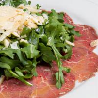 Carpaccio Di Manzo Con Rucola E Parmigiano E Scaglie Di Tratufo Nero · Thin slices of raw “black Angus” filet mignon with arugula and shaved Parmesan cheese.