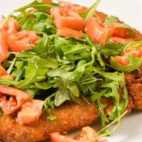 Costata Di Vitello Alla Milanese · Veal chop butterfly Milanese style served with arugula and tomatoes.