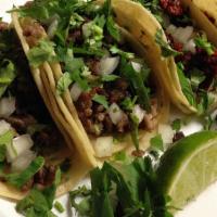 Tacos De Carnitas · pork tacos 
onios and cilantro