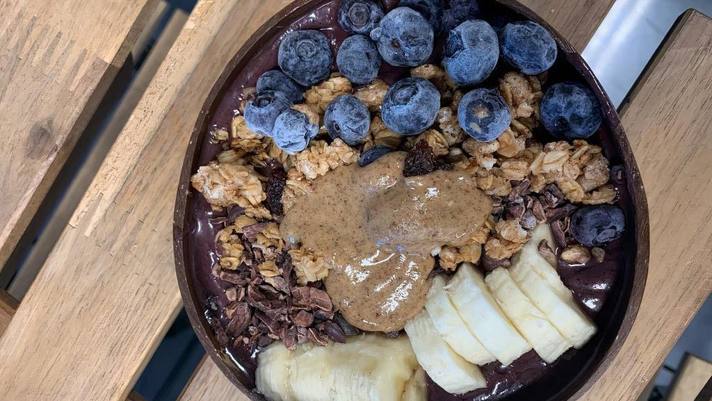 Amazonian Acai Bowl · Acai, banana, blueberries, pineapple, and almond milk. Topped with banana, blueberries, coconut flakes, peanut butter, and granola.