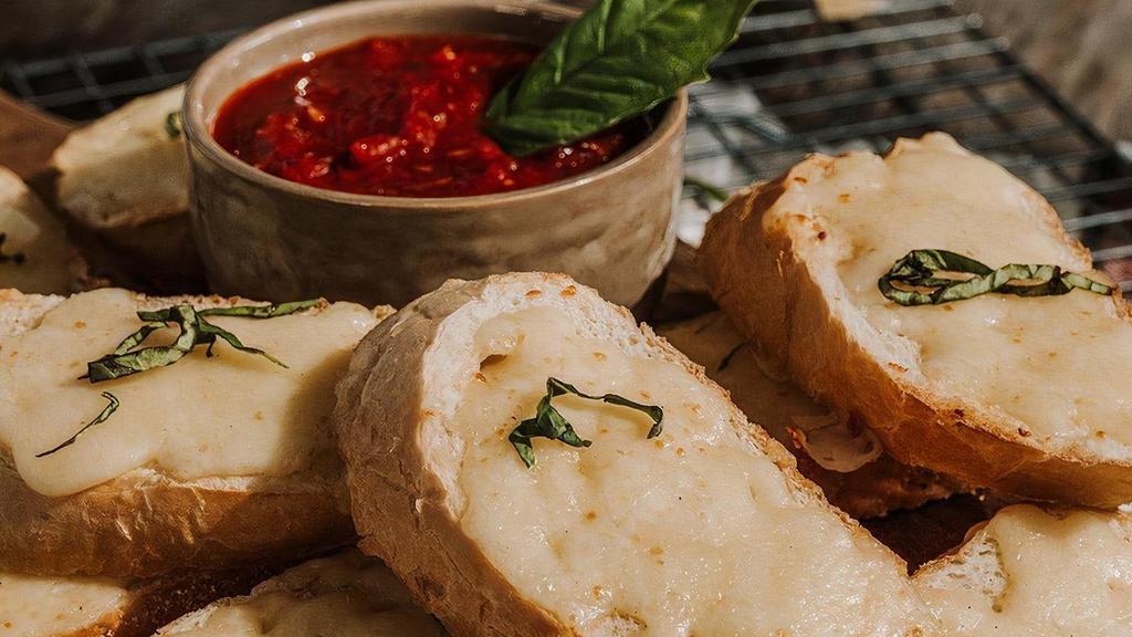 Cheesy Garlic Bread · Toasted French baguette with roasted garlic and mozzarella, fresh basil and our signature red sauce.