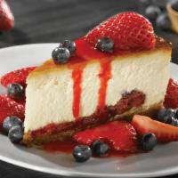 Cheesecake With Fresh Berries · New York-style cheesecake on a graham cracker crust, fresh strawberries & blueberries, drizz...