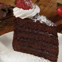 Dark Chocolate Fudge Cake  · Four layers of chocolate cake & rich fudge frosting, whipped cream, powdered sugar & a straw...