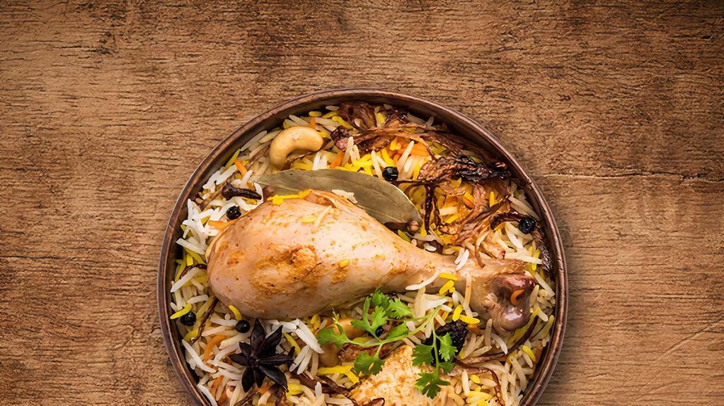 United Chicken Biryani · Tender morsels of chicken meat cooked with our signature biryani masala gravy and long grain premium basmati rice, served with a side of yogurt raita