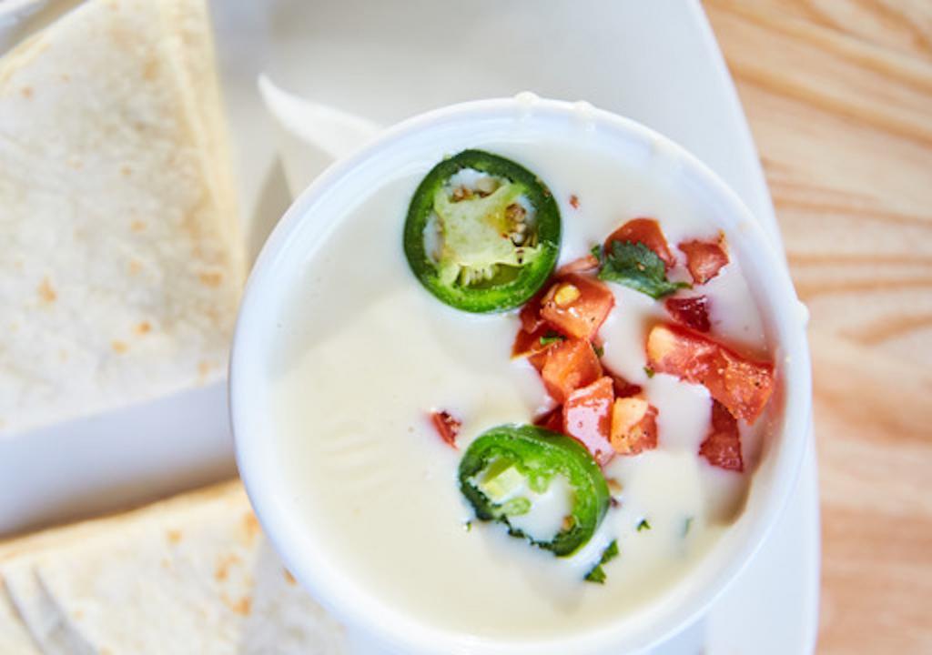 Queso · Our white cheese dip topped with jalapeños and pico de gallo. Served with tortilla chips or warm tortillas.