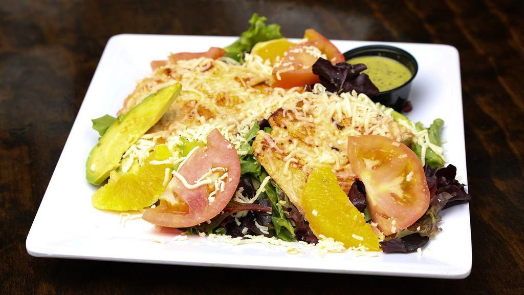 Ensalada Tropical · Fresh spring mix salad topped with slices of oranges, tomatoes, avocado, crumbled cheese and side of our cilantro dressing.