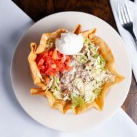 Taco Salad · A flour tortilla shell filled with shredded chicken or ground beef in a bed of lettuce toppe...
