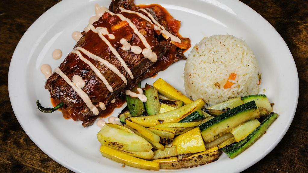 Camaron Poblano Asada · Grilled steak or asada chicken wrapped around a poblano pepper filled with shrimp, mushrooms, pico de gallo, and shredded cheese topped with chipotle cream. Served with a side of rice and grilled zucchini squash.