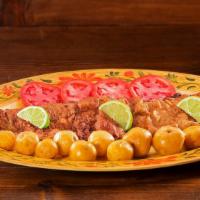 Chuletazo · Fried breaded pork loin, with your choice of one side, one slice of tomato and limes.
