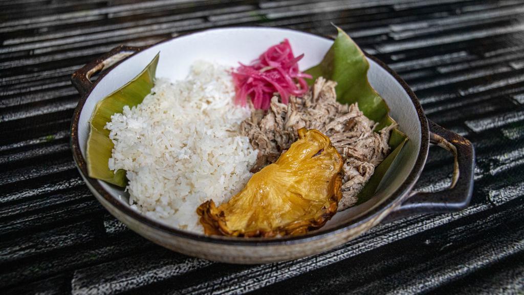 The Luau Pig · Slow roasted pork shoulder on banana leaf with hawaiian salt, coconut rice, and pickled onion.