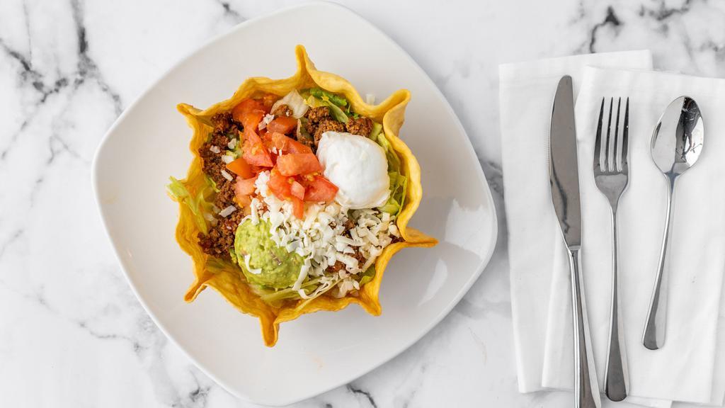 Taco Salad · Seasoned shredded beef or chicken served on a bed of lettuce topped with guacamole, tomato, and sour cream.