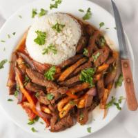 Lomo Saltado · Beef tenderloin strips with sautéed red onions and tomatoes served with white rice and frenc...