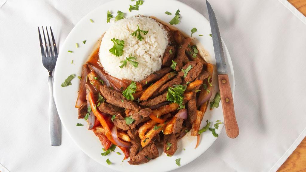 Lomo Saltado · Beef tenderloin strips with sautéed red onions and tomatoes served with white rice and french fries.