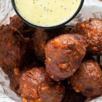 Hot Shots · Our made in house sausage fritters with a lot of heat and a ton of cheese. Served with honey...
