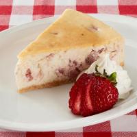 Strawberry Cheesecake · Strawberry cheesecake served with fresh sliced strawberries and whipped cream.