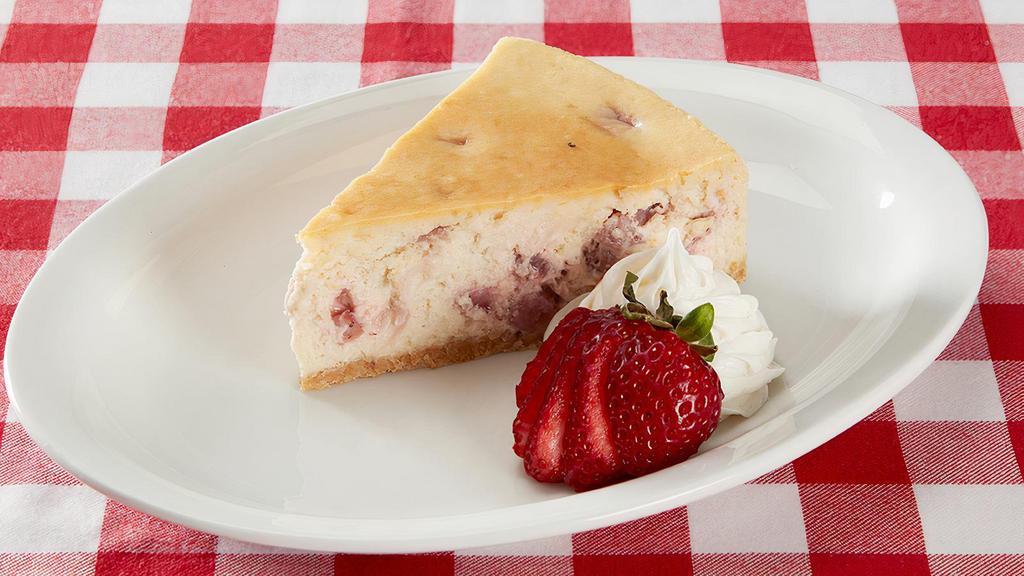 Strawberry Cheesecake · Strawberry cheesecake served with fresh sliced strawberries and whipped cream.