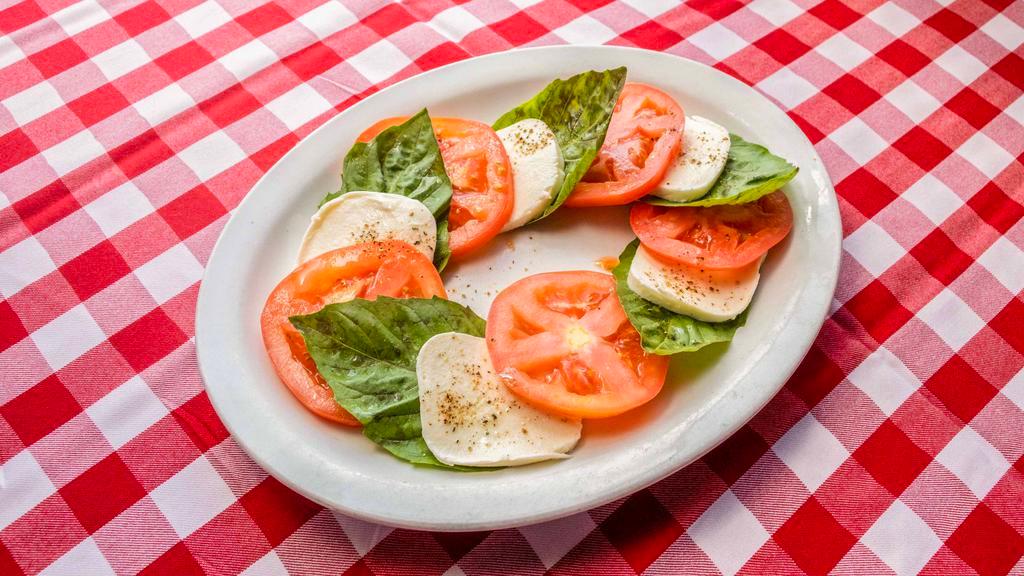 Caprese · Slices of Fresh Mozzzarella, Tomatoes and Fresh Basil, drizzled with Extra Virgin Olive Oil.