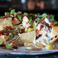 Backyard Bbq Pork Nachos · Crispy pork, black beans & roasted corn topped with our Amber Ale queso, house pineapple sal...