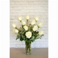 One Dozen Deluxe White Roses · One dozen deluxe white roses, along with seasonal foliage, are designed in a tall oblong vas...