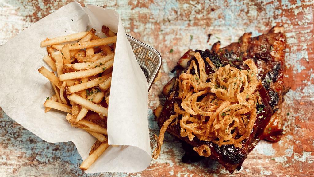 Dolores Baby Back Ribs · St. louis style ribs so tender they fall off the bone with shoestring fries on side and a pair of gloves.