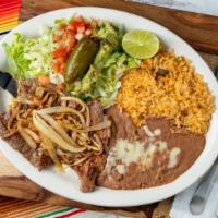 Steak A La Tampiqueña · Steak cooked with onions served with rice, beans, lettuce, guacamole and tortillas.
