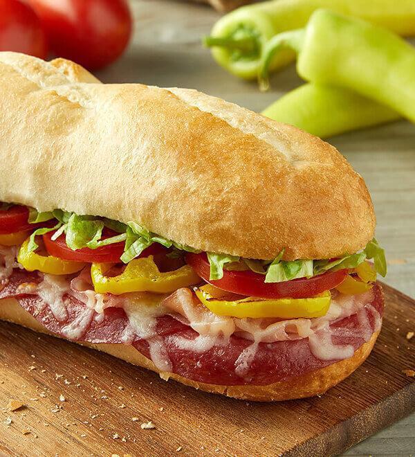 Big Don Italian With Sausage · Shaved ham, sliced salami, smoked Provolone, family recipe sausage, banana peppers, freshly cut Roma tomatoes, lettuce, house Italian dressing.