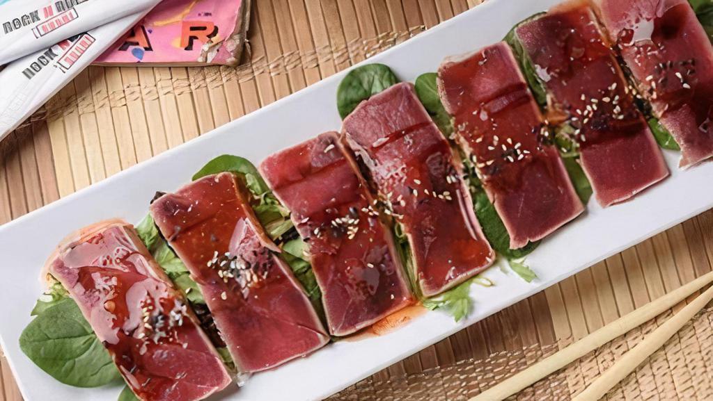 Tuna Tataki · Red tuna lightly seared, sliced, drizzled with sweet chili, ponzu and eel sauces and finished with a sprinkle of sesame seeds. A rare treat.