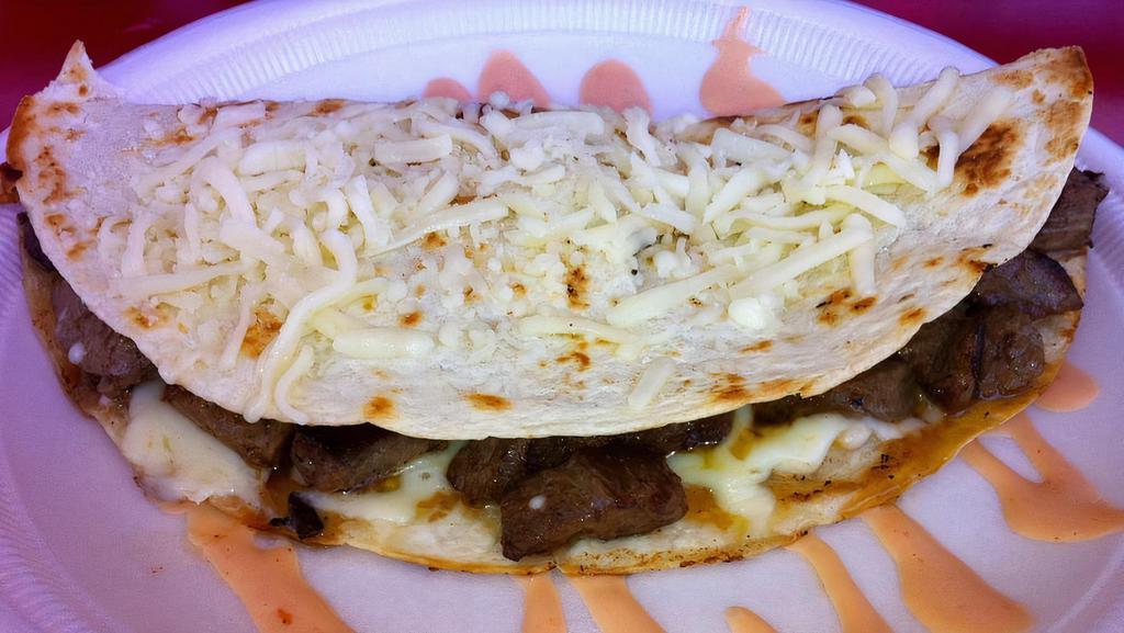 De Carne O Pollo A La Plancha · Quesadilla of grilled meat or chicken served on a large flour tortilla with mozzarella cheese, pink, green, pineapple sauces, and potato sticks.