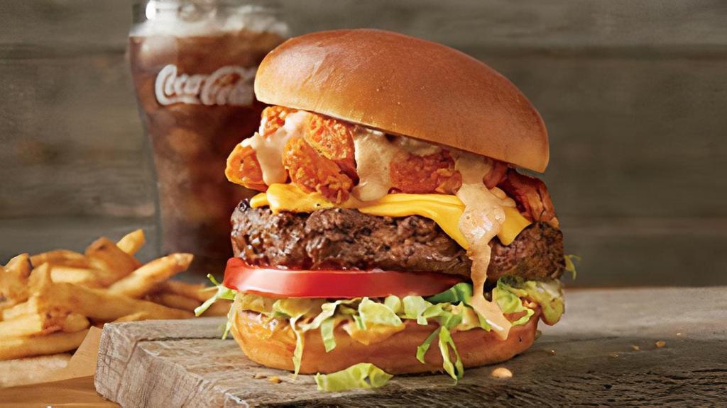 The Bloomin' Burger® · Topped with Bloomin' Onion® petals, American cheese, spicey house-made pickles, onion, lettuce, tomato and our spicy signature bloom sauce.  Served with one freshly made side.