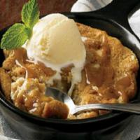 Caramel Cookie Skillet · A warm salted caramel cookie with pieces of white
chocolate, almond toffee and pretzels, toa...