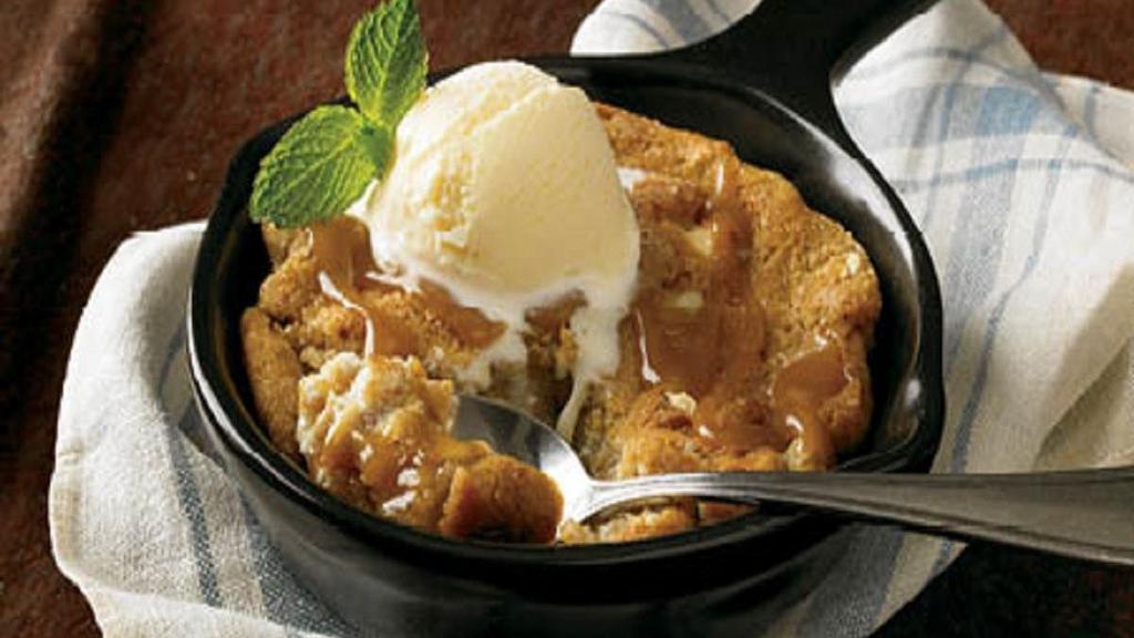 Caramel Cookie Skillet · A warm salted caramel cookie with pieces of white
chocolate, almond toffee and pretzels, toasted in a skillet
and topped with vanilla ice cream.