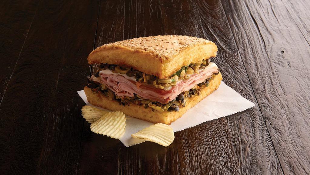 1/4 Ham And Salami Muffaletta(520 Cal) · A New Orleans original! Grilled, crusty Muffaletta bread spread to the edges with our family-receipt olive mix and provolone is melted over layers of nitrite ham and salami. Served with chips or baked chips (150/100 cal) and a pickle (5 cal).