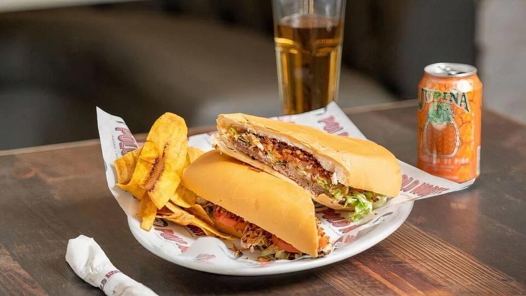 Pan Con Bistec · Steak sandwich topped with grilled onions, lettuce, tomatoes  and papitas julianas.