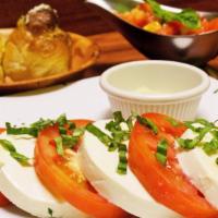 Caprese Salad · Vegetarian. Sliced tomatoes and fresh homemade mozzarella topped with a touch of pesto, home...