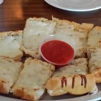 Cheesy Garlic Bread · Fresh homemade bread topped with garlic butter and mozzarella cheese. Served with homemade m...