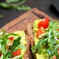 Tostada De Aguacate · Grilled sourdough bread with avocado spread, heirloom tomato and cucumbers. Garnished with f...